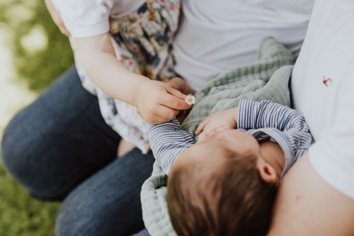 Ein Kind gibt einem Baby eine Blume.