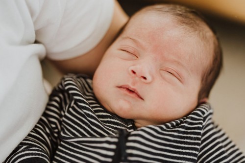 Ein kleines Baby auf dem Arm einer Frau.