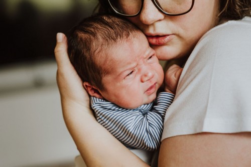 Eine Frau hält ein kleines Baby auf dem Arm.
