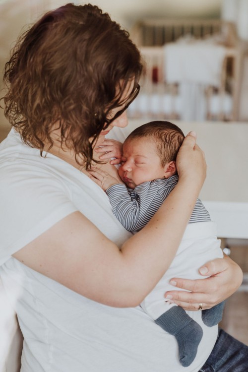 Eine Frau hält ein Baby an ihrer Brust.
