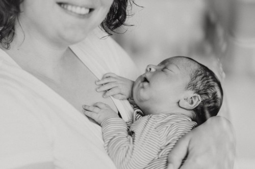 Ein kleines Baby schläft auf dem Arm einer Frau.