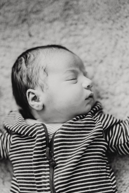 Ein kleines Baby schläft auf einem Teppich.