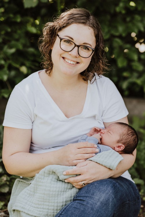 Ein kleines Baby bei einer Frau auf dem Schoß.