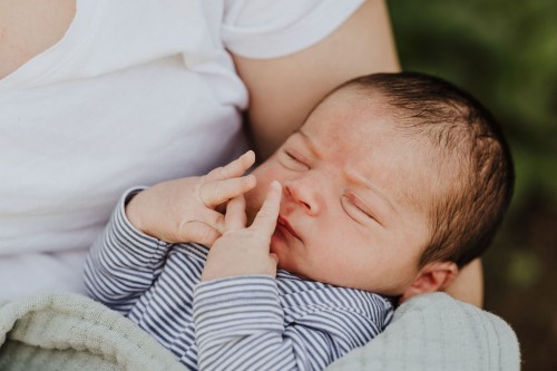Ein kleines Baby bei einer Frau auf dem Schoß.