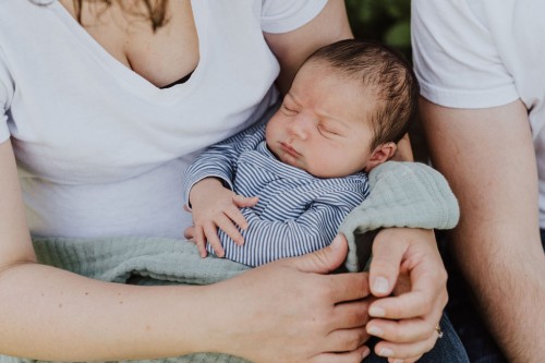Ein kleines Baby bei einer Frau auf dem Schoß.