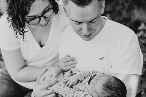 Eine Frau und ein Mann schauen sich ein kleines Baby an.