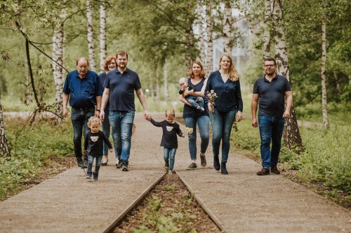 Großeltern, Eltern und Kinder gehen zusammen den Weg im Wald auf dem Gelände der Zeche Zollverein