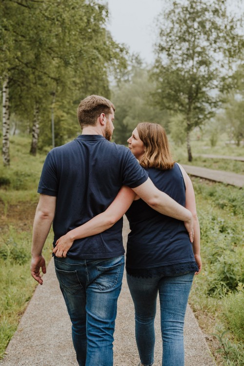 Das Paar geht umarmt zusammen den Weg auf dem Gelände von Zeche Zollverein