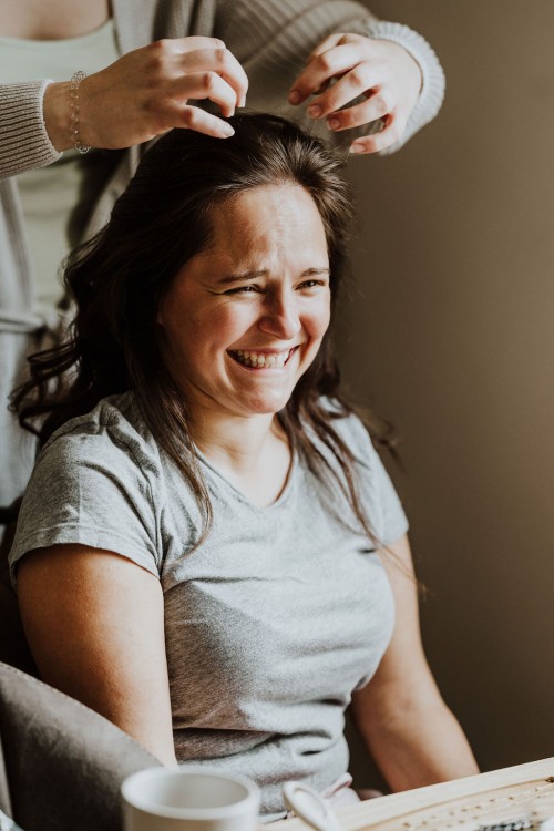 Einer Frau werden die Haare gestyled.