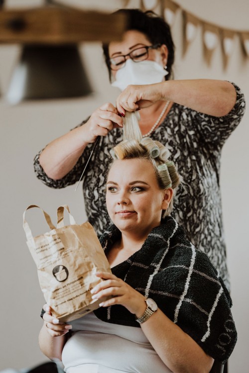 Einer Frau werden Lockenwickler eingedreht.