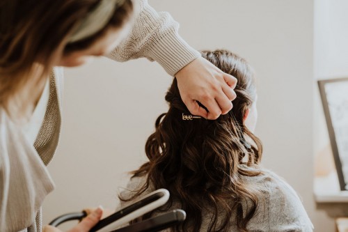 Eine Frau macht einer anderen die Haare.