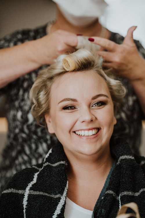 Einer Frau werden die Lockenwickler eingedreht.