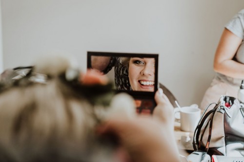 Eine Frau sieht sich im Spiegel.