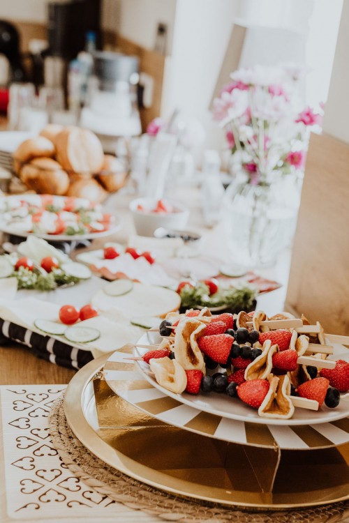 Ein Tisch mit Obst und Pancakes.