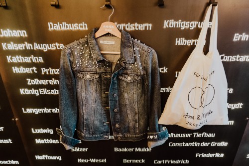 Brautjeansjacke mit Jutebeutel vor Zechenwand