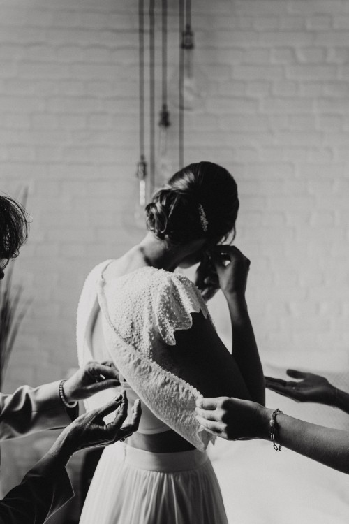 Gettingready Braut legt Schmuck an in schwarzweß