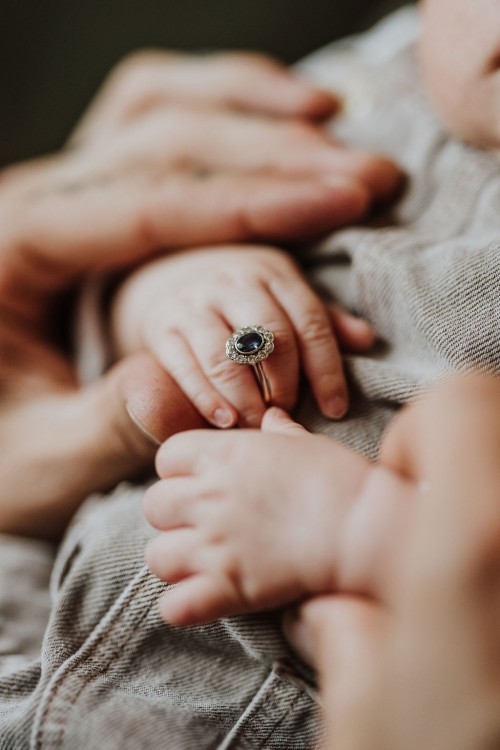 Ein kleines Baby hält in seiner Hand einen Ring fest.