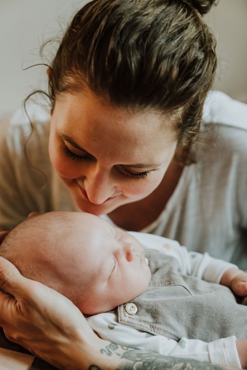 Eine Frau schaut sich ein kleines Baby ganz nah an.