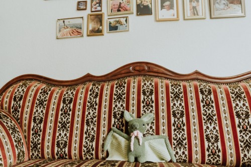 Eine Stofftier-Fledermaus auf einem Sofa.