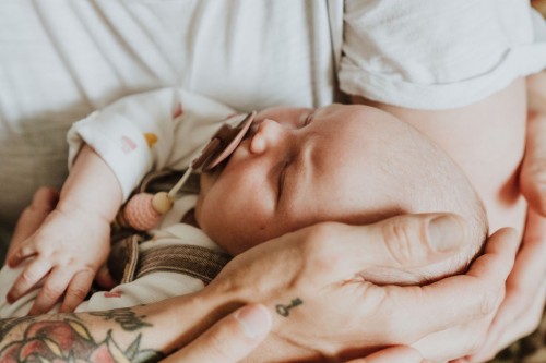 Ein kleines Baby auf dem Arm bei einer Frau.