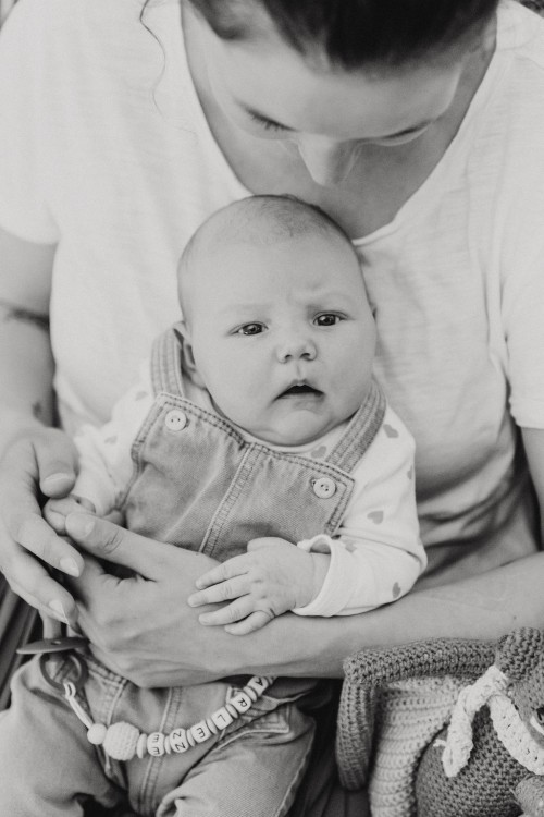 Ein kleines Baby bei einer Frau auf dem Schoß.