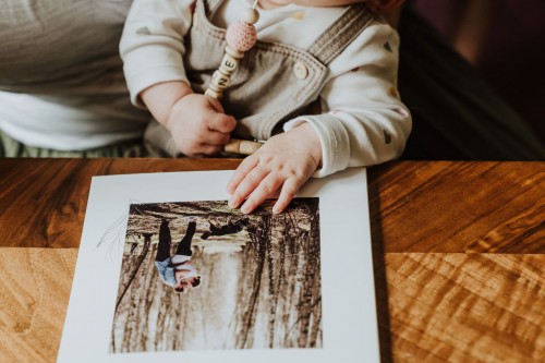 Ein kleines Baby schaut sich ein Bild an.