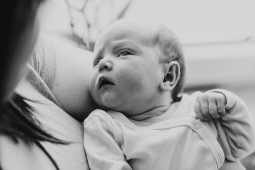 Ein kleines Baby auf dem Arm einer Frau.