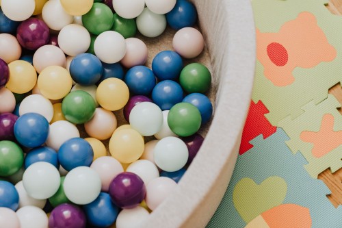Ein Bällebad und ein Puzzle-Teppich.