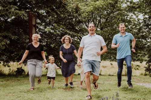 Eine Gruppe von Menschen die durch die Wiese rennen