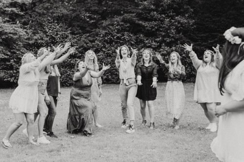 Eine Gruppe von Frauen versucht einen Blumenstrauß zu fangen.