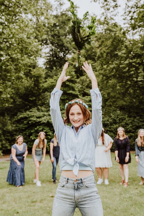 Eine Frau wirft einen Blumenstrauß hoch.