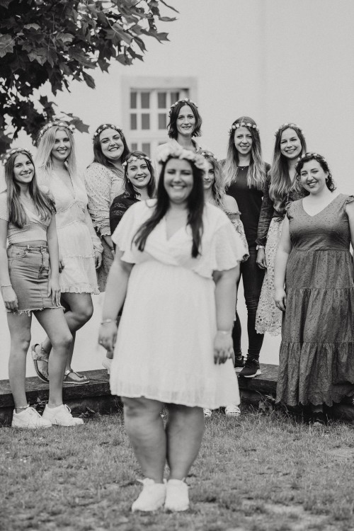 Eine Gruppe von Frauen sthen vor einem Gebäude.