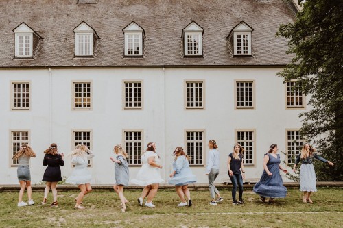 Eine Gruppe von Frauen tanzen vor einem Gebäude.