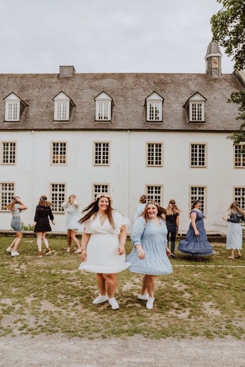 Eine Gruppe von Frauen tanzen vor einem Gebäude.