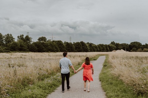 Ein Mann und eine Frau gehen einen Feldweg entlang.