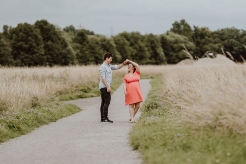 Ein Mann und eine Frau tanzen auf einem Feldweg.