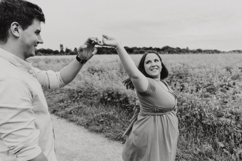 Ein Mann und eine Frau tanzen auf einem Feldweg.