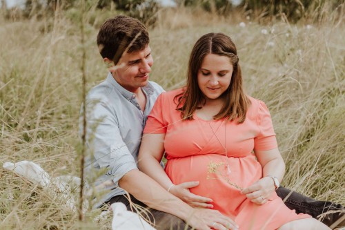 Ein Mann und eine Frau sitzen auf einer Wiese.