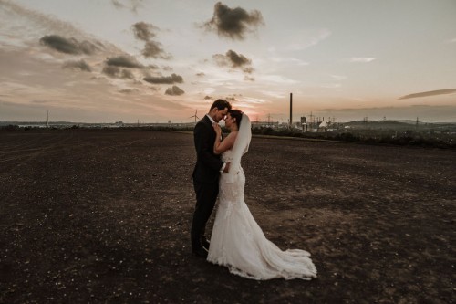 Farbfoto Hochzeitspaar im Sonnenuntergang auf Halde