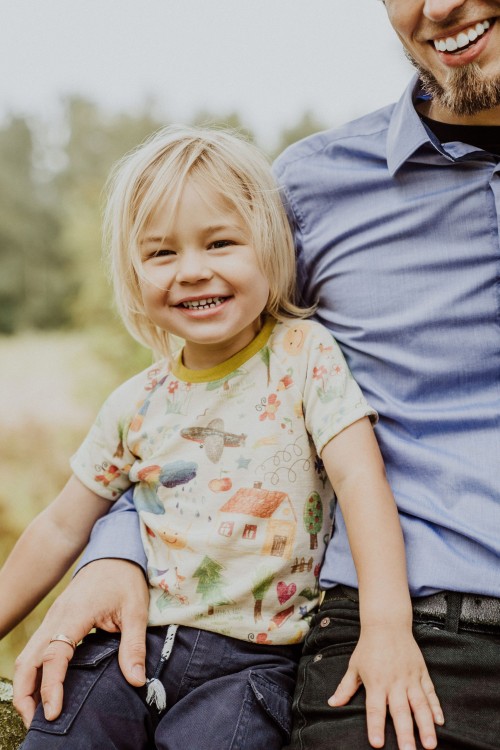 Ein fröhliches Kind neben einem Mann.
