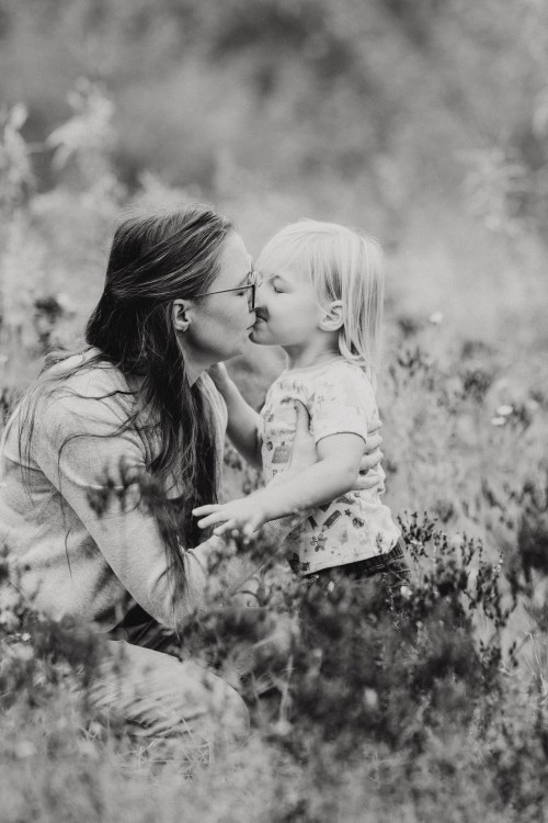 Ein Kind gibt einer Frau ein Küsschen.