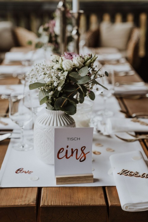 Festliche Dekoration und Blumen in einer Vase auf einem Holztisch.
