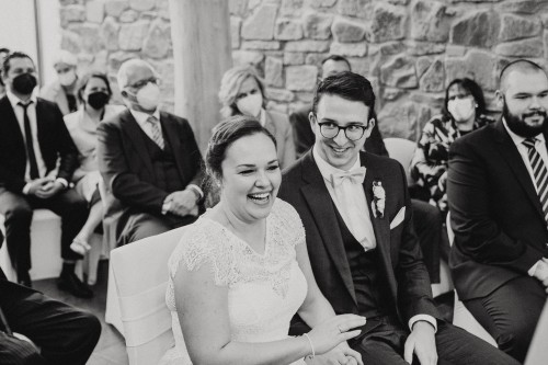 Ein schwarz-weißes Bild von einem Brautpaar und deren Gästen.