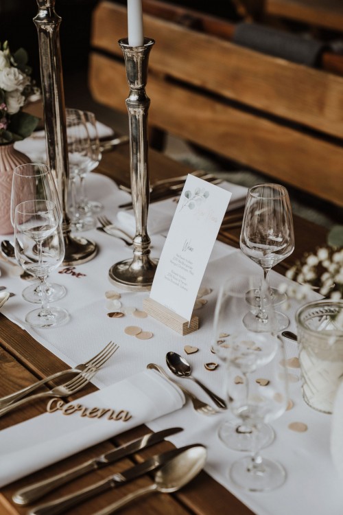 Festliche Dekoration und Besteck auf einem Holztisch.