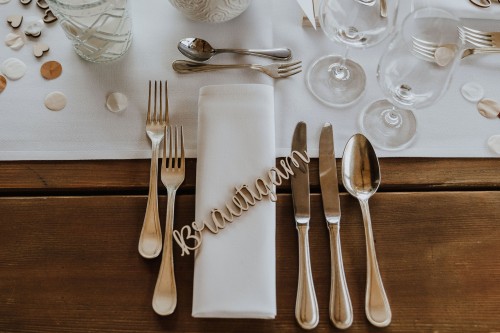 Ein Schriftzug und Besteck auf einem Tisch.