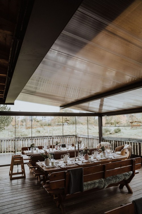 Festlich dekorierter Tisch in einem Wintergarten.