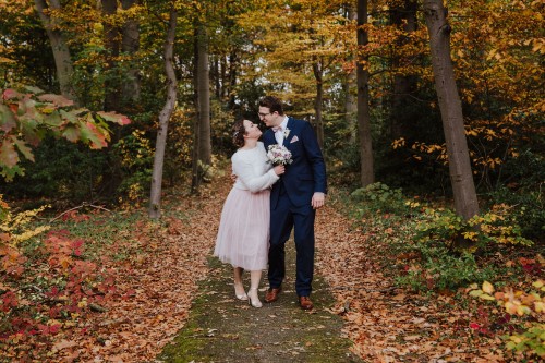 Ein Brautpaar umarmt sich auf einem Waldweg.