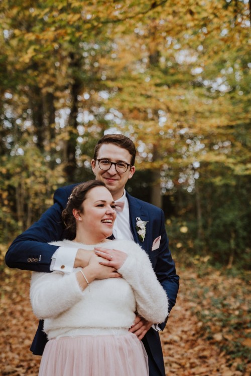 Ein Bräutigam umarmt eine Braut.