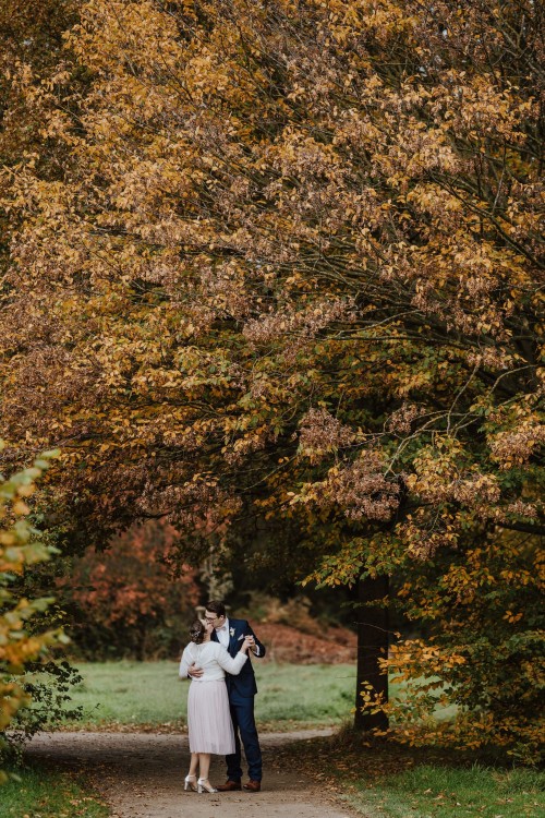 Ein Brautpaar küsst sich unter einem großen Baum.
