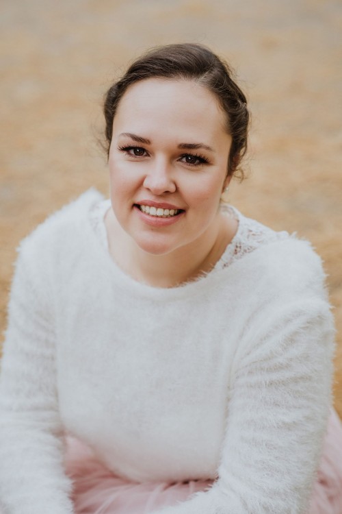 Eine Frau schaut lächelnd in die Kamera.